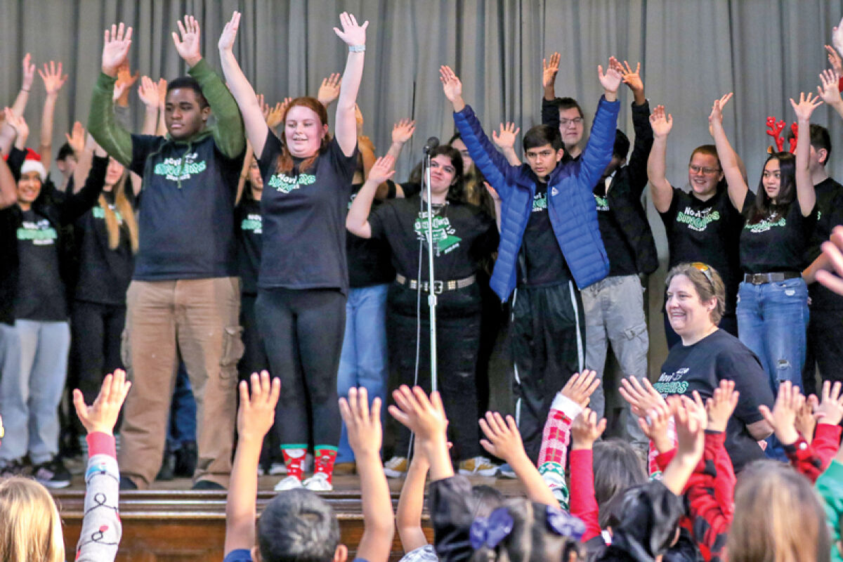  The Novi Singers play “Simon Says” with students at the Academy of the Americas Dec. 12 before performing Christmas carols. 