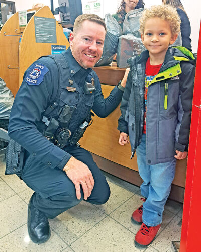  Novi police officer Adam McGee came in on his day off to help Calvin Stewart, 5, shop for clothes and other necessities. 