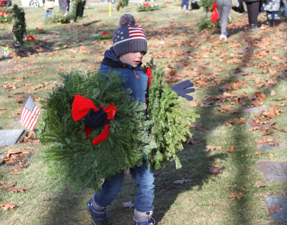  Noah Muckelvaney, 7, of Shelby Township, carries a few wreaths to be placed on the graves of veterans at Resurrection Cemetery in Clinton Township. The veteran tributes were part of Wreaths Across America’s event on Dec. 14. 