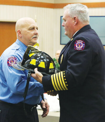  Macomb Township Fire Chief Robert Phillips shakes hands with Michael Wiedbusch, who served 26 years with the Macomb Township Fire Department. 