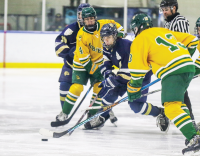  Grosse Pointe South junior  Liam O’Donaghue attempts to fight through two Grosse Pointe North players.  