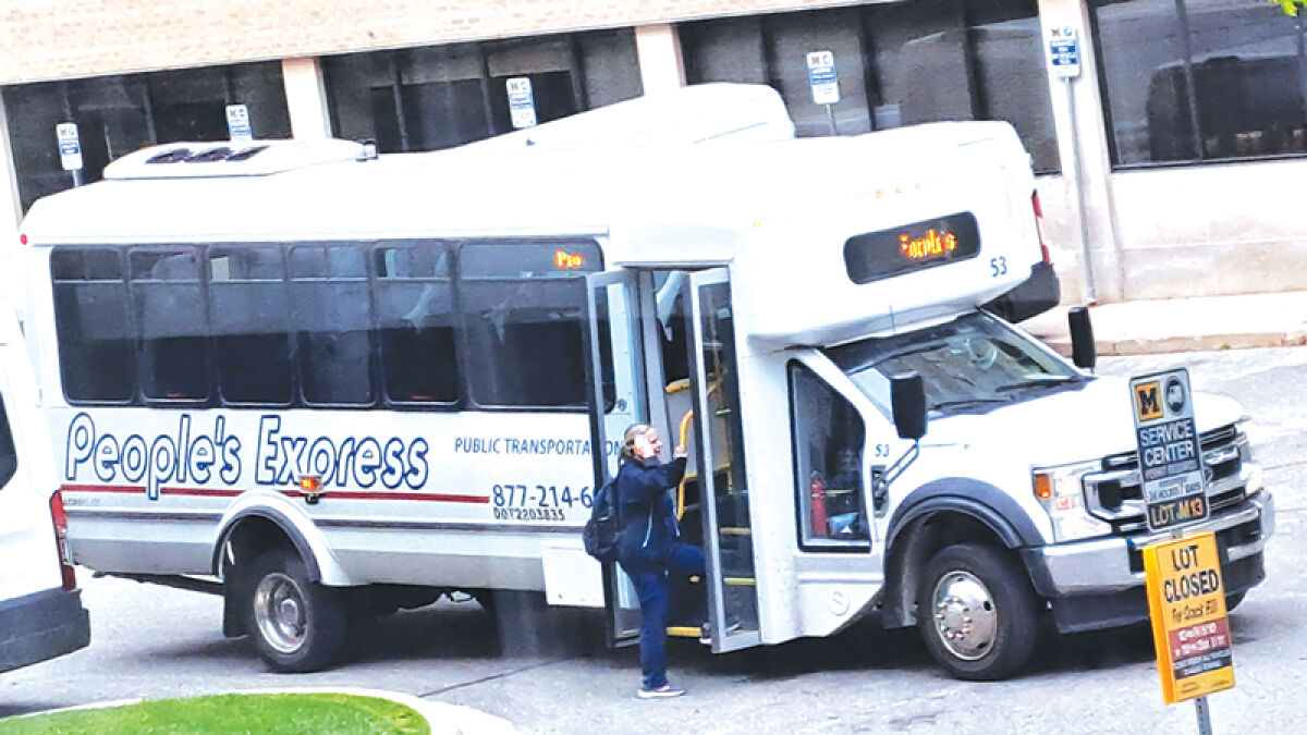  A woman gets on a People’s Express bus outside the University of Michigan Hospital in Ann Arbor on May 14, 2024. 