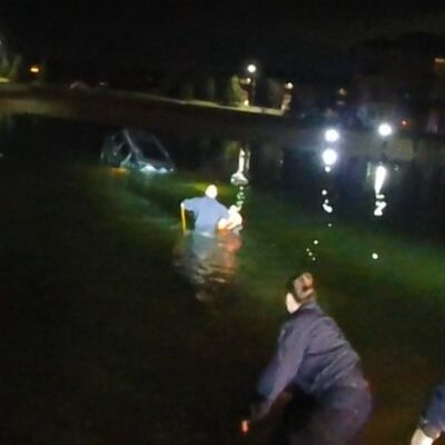  This photo shows Clinton Township police officers rescuing a driver sinking in a retention pond at The Harbours apartment complex on New Year’s Eve. 