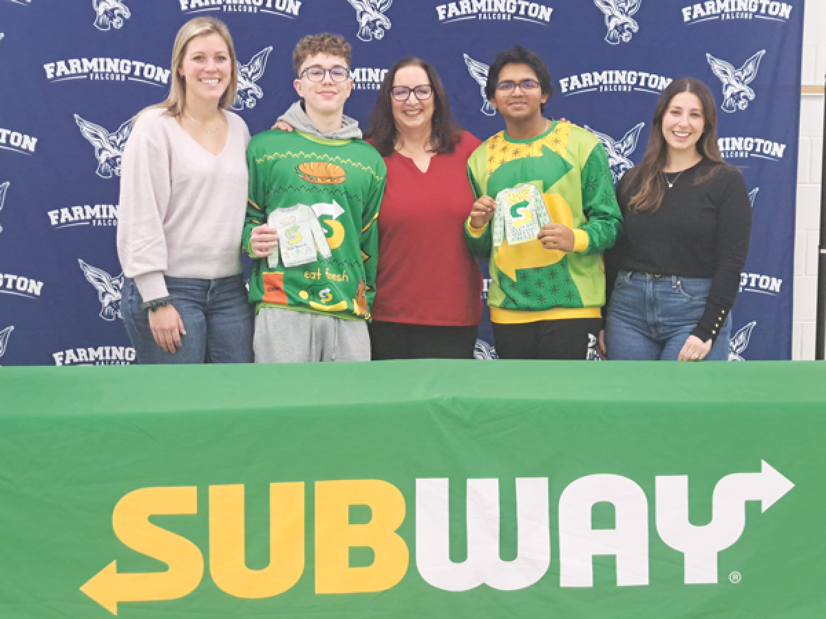  Farmington High School students Ethan Croll and Vithesh Balla pose for a picture, wearing the Subway-themed “ugly sweaters” they designed. Also pictured is Subway franchisee Jakki Zirbel, left, the students’ marketing instructor, Nina Merget, center, and Paige Hyman, Subway’s senior manager of communication and brand PR.  