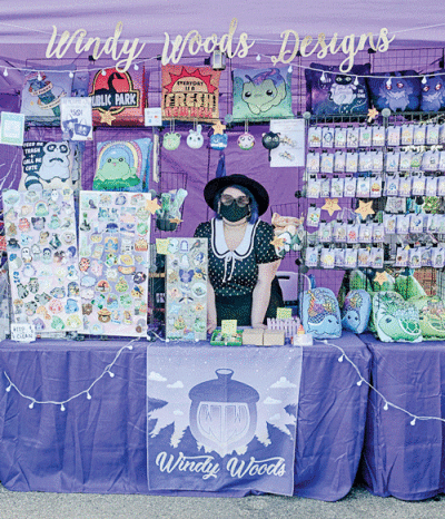  Windy Woods, of Warren, stands at her booth at last year’s DIY Street Fair, where she sold stickers and pins. 